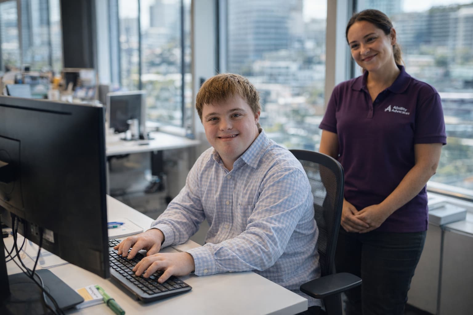 Young man with Down syndrome working confidently with job coach