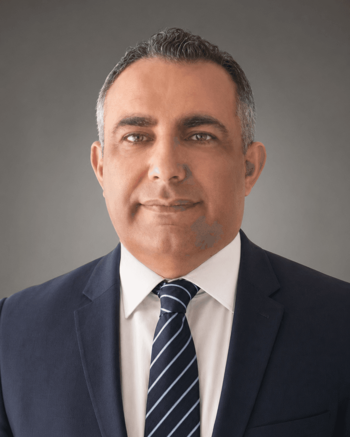 Professional headshot of a middle-aged man wearing a navy suit and striped blue tie.